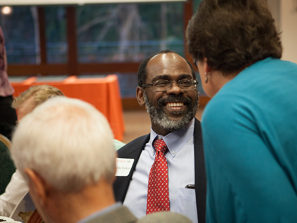 Ofodike "DK" Ezekoye laughing while speaking to group of people.