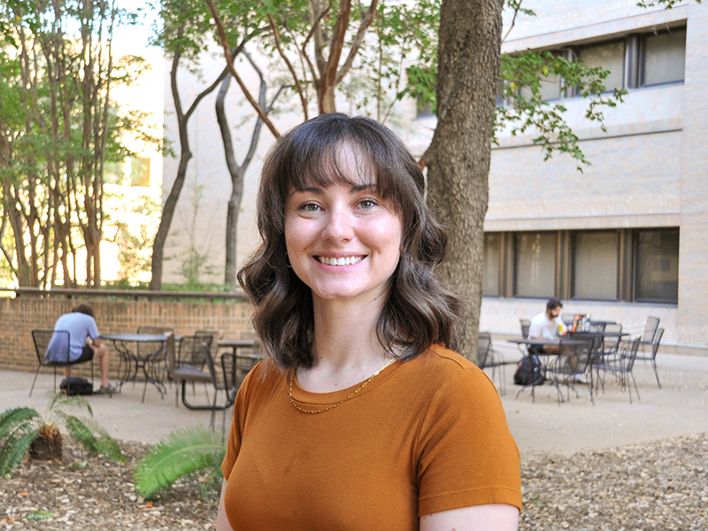 Libby McSwain smiling in front of Mechanical Engineering building on UT Austin campus.