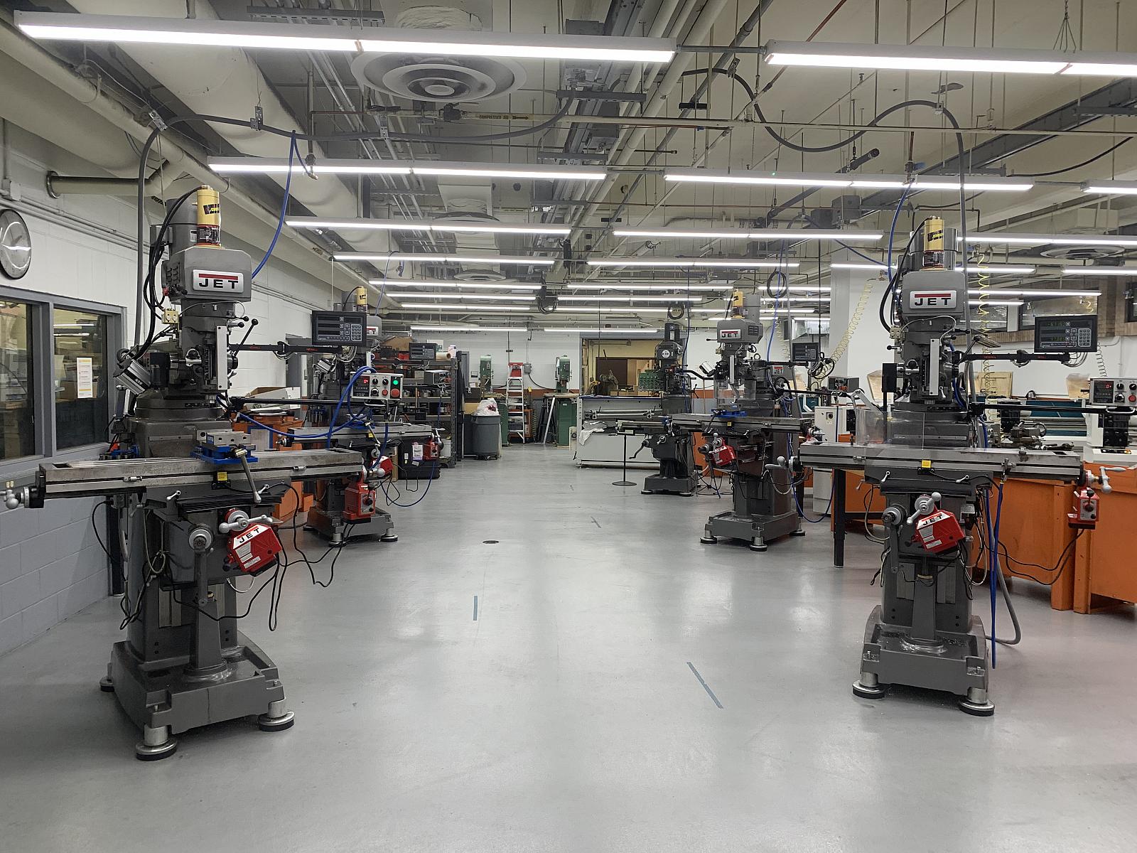 ME machine shop machines in room with flourescent lightts above and concrete floor