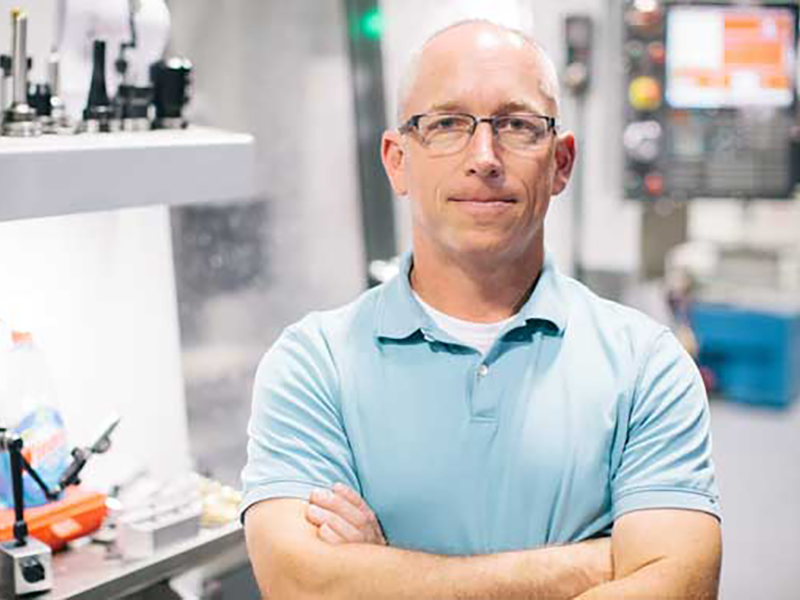 David Leigh standing with arms crossed in laboratory.