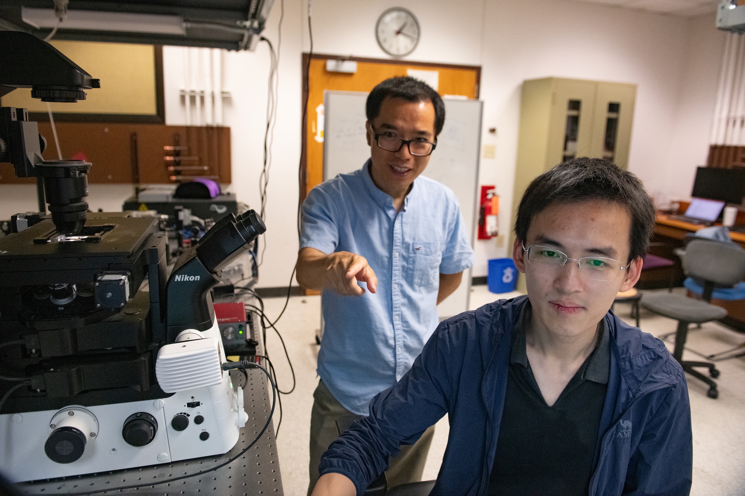 Yuebing Zeng mentors a graduate student in his lab.