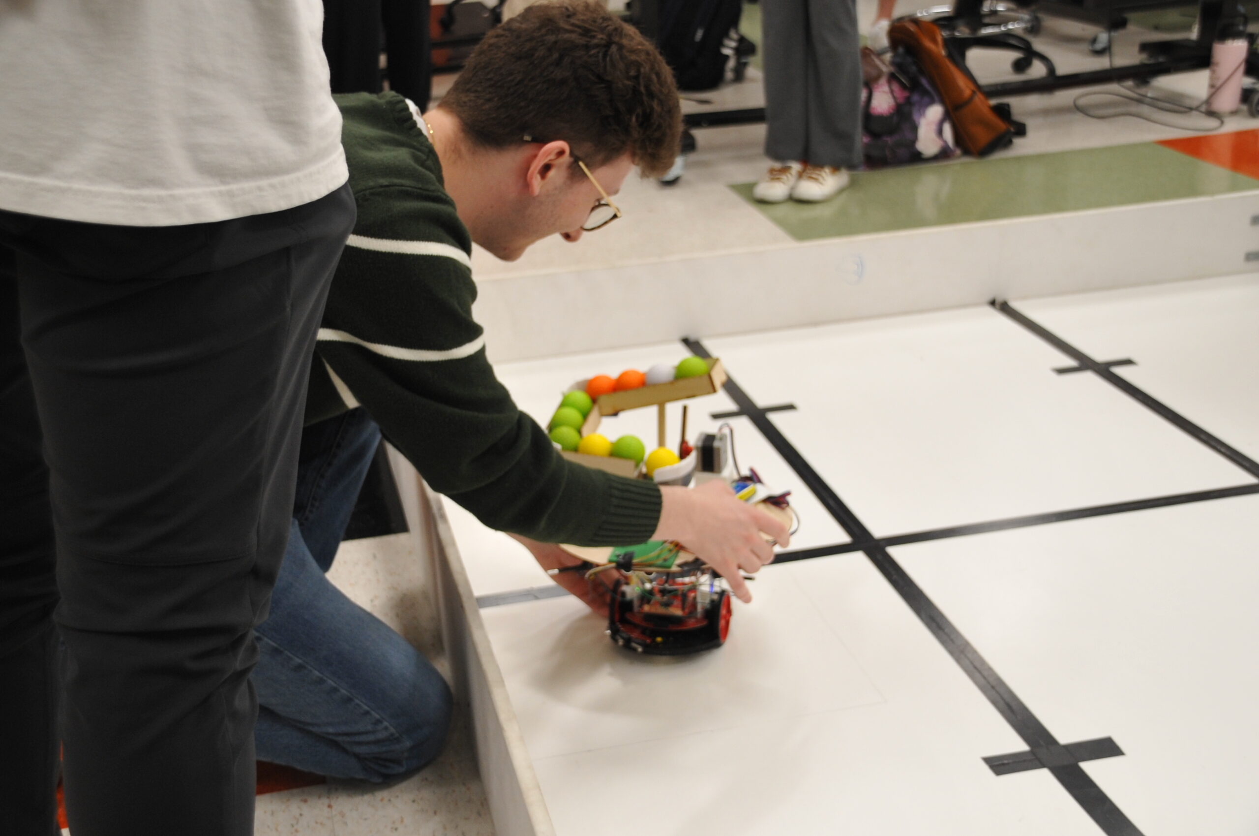 A Texas Engineering student sets up a robot for a competition.