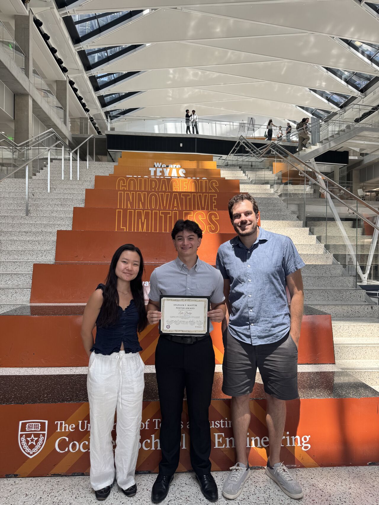three mechanical engineering students by the stairs in the EER building